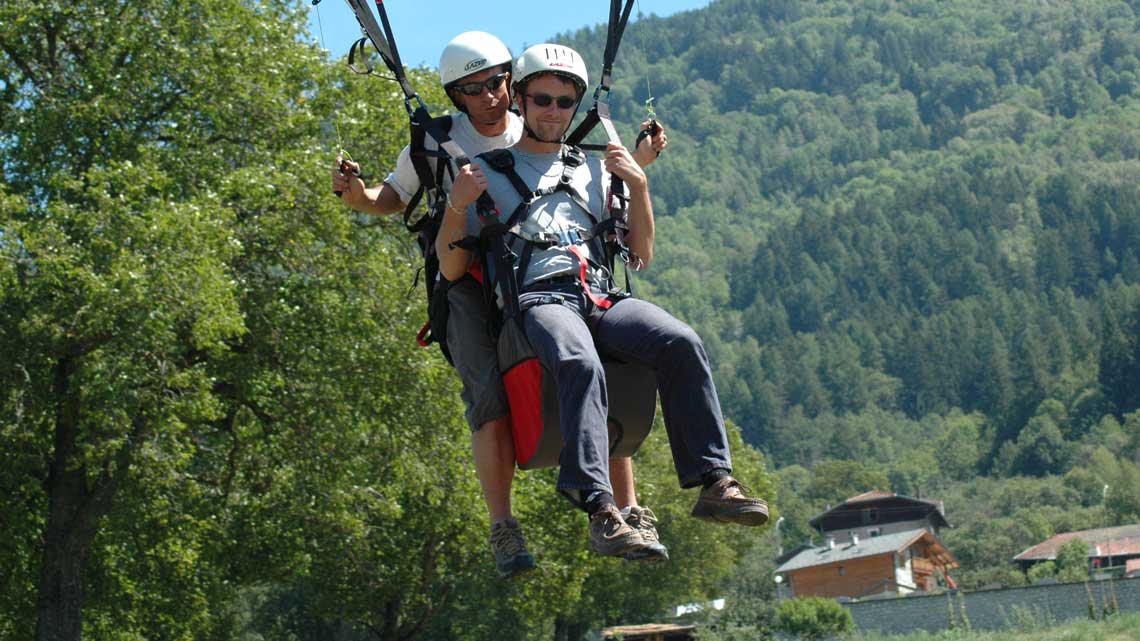 Tandem paraglider on landing approach at the Ilettes terrain in Bourg Saint Maurice